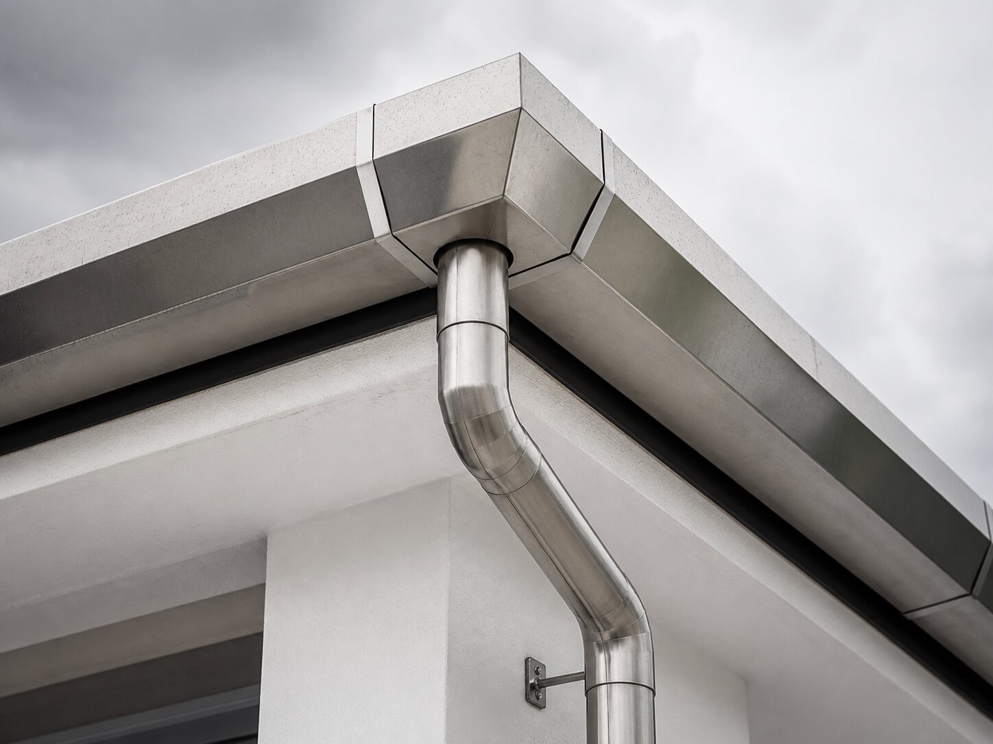 Finished stainless steel gutter joint and downpipe detail for a Puchong home